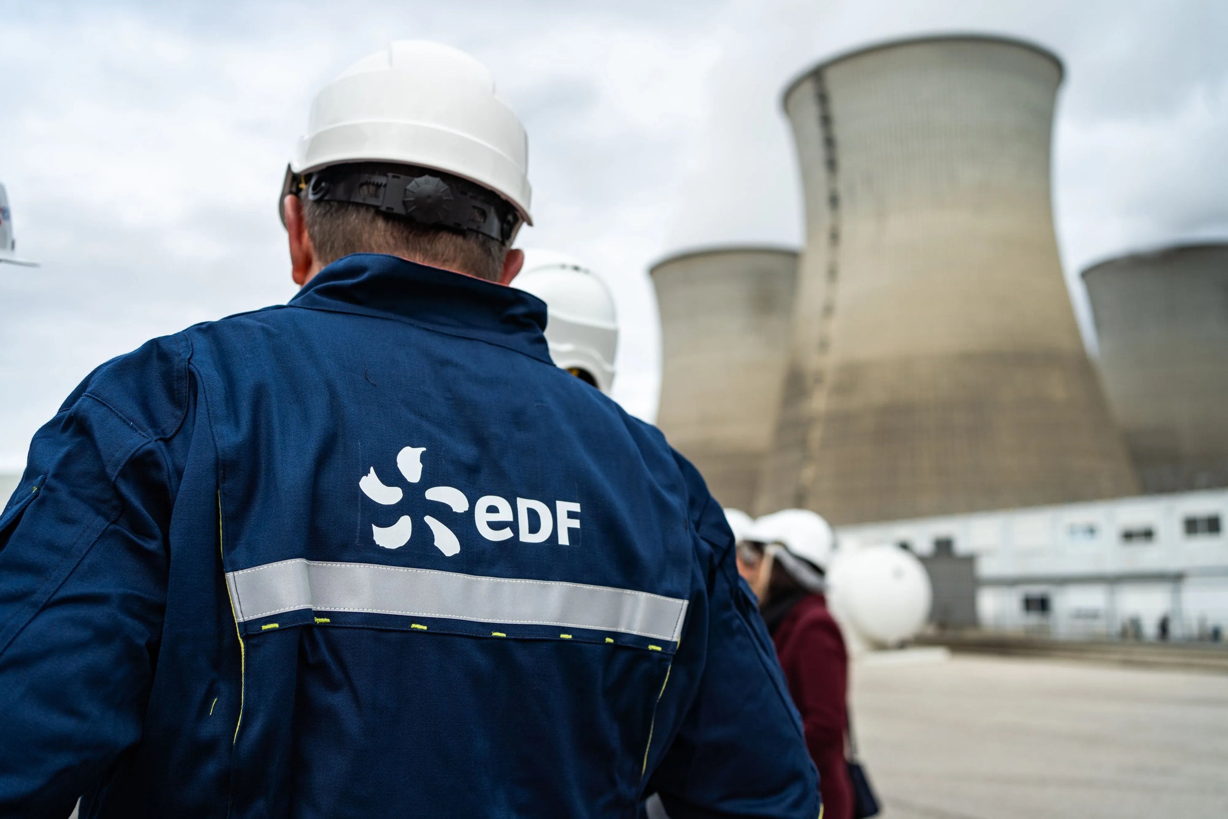 homme de dos avec des EPI et un casque de protection sur une centrale nucléaire