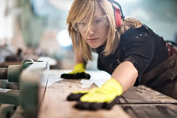 femme portant des EPI et un casque de protection auditives